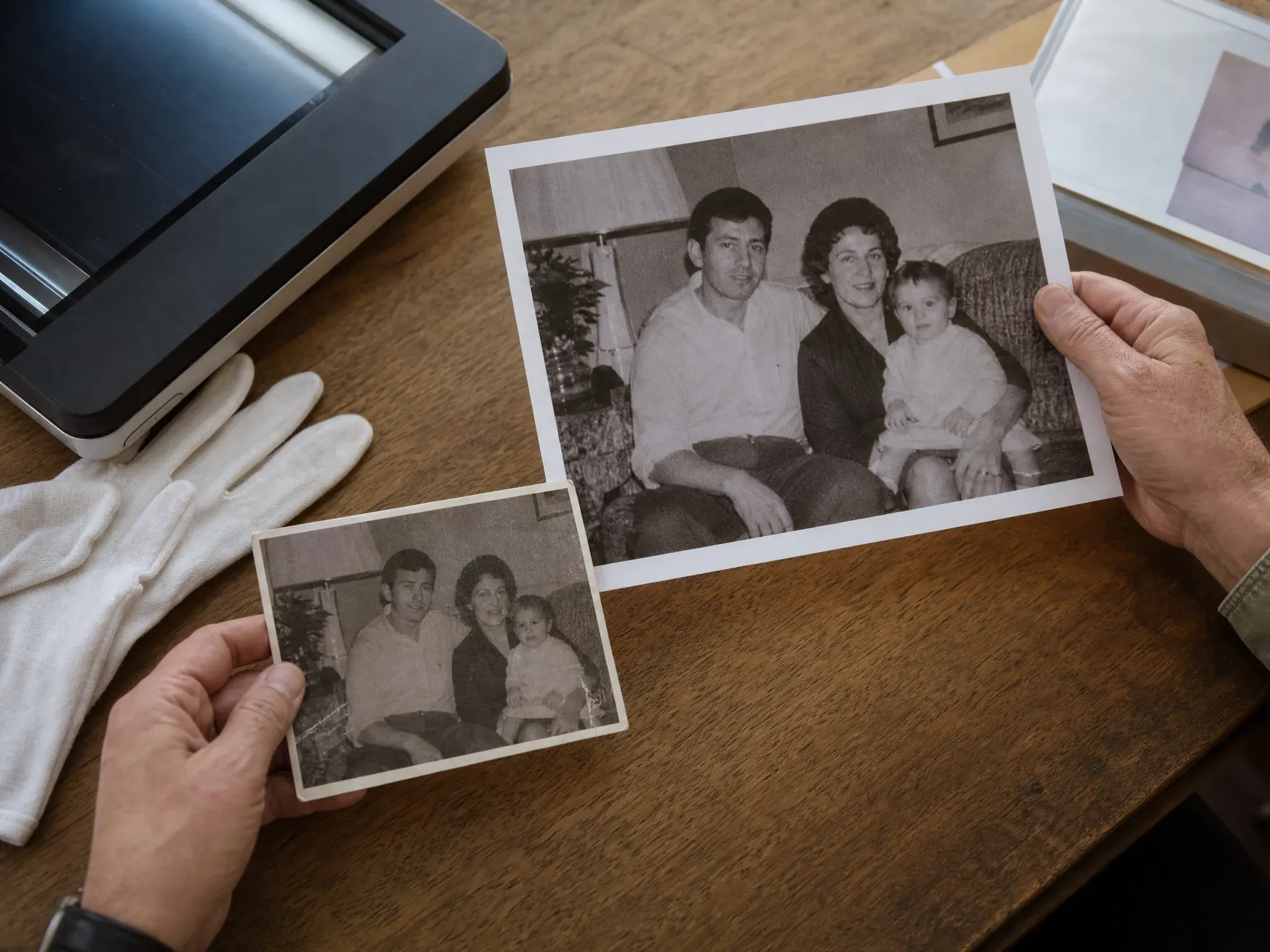 Old family photo beside a clearer enhanced print on an archive desk